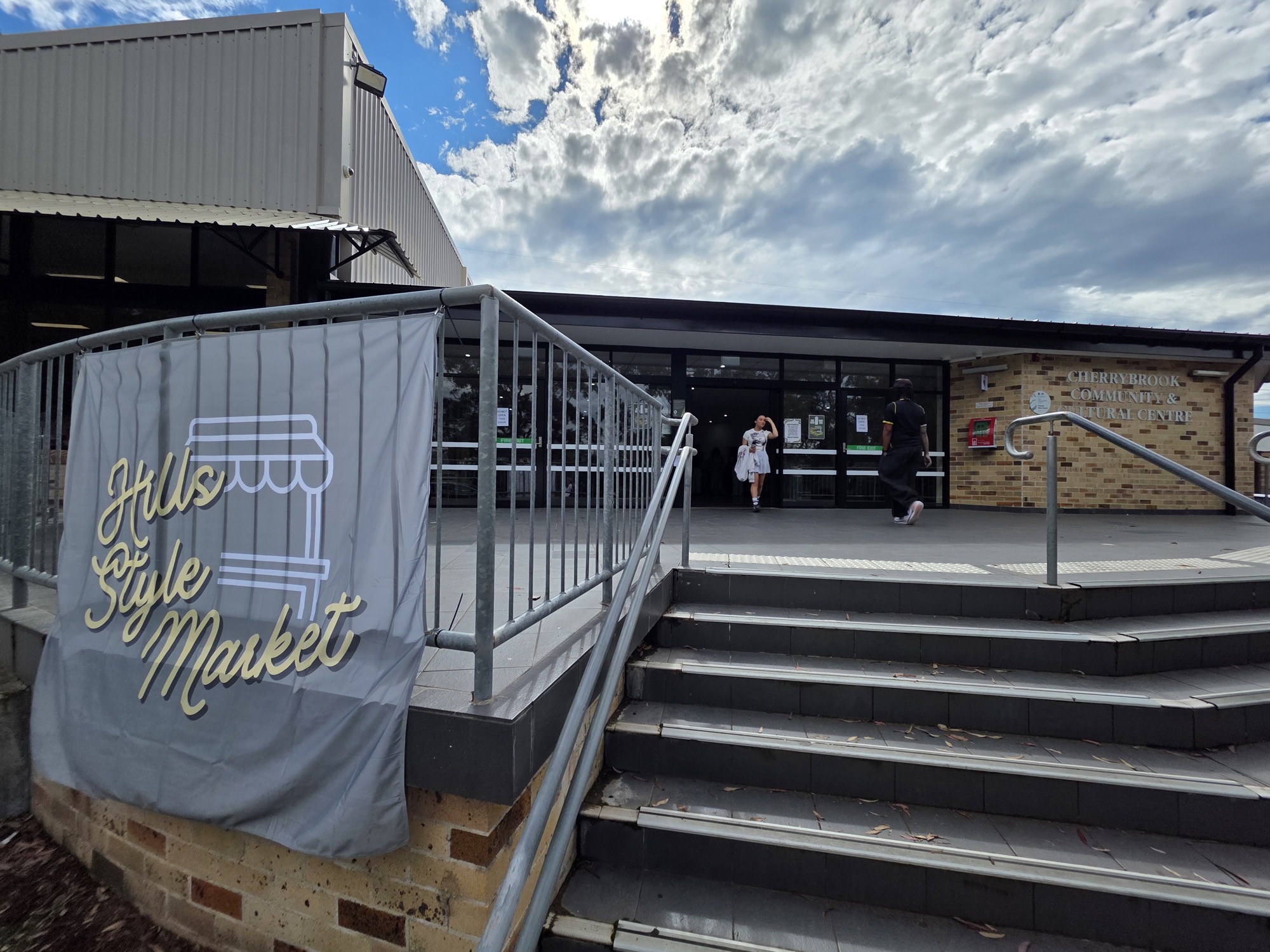 The Hills Style Market banner hanging by the stairs at the Cherrybrook Community and Cultural Centre entrance