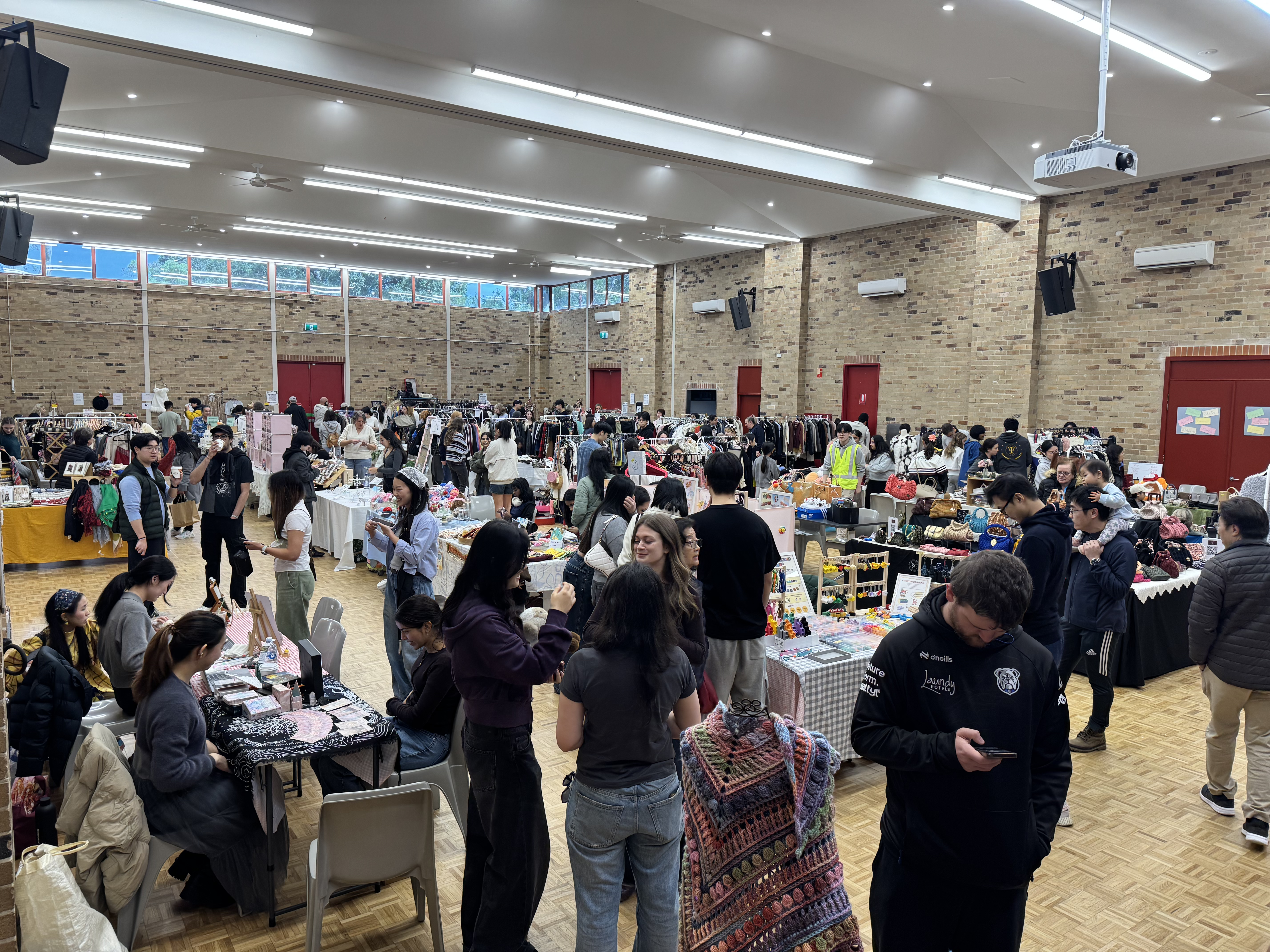 Indoor market with clothing racks and shoppers